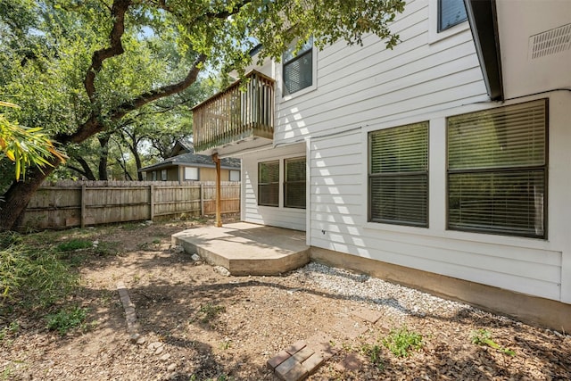 view of yard featuring a patio, a balcony, and fence