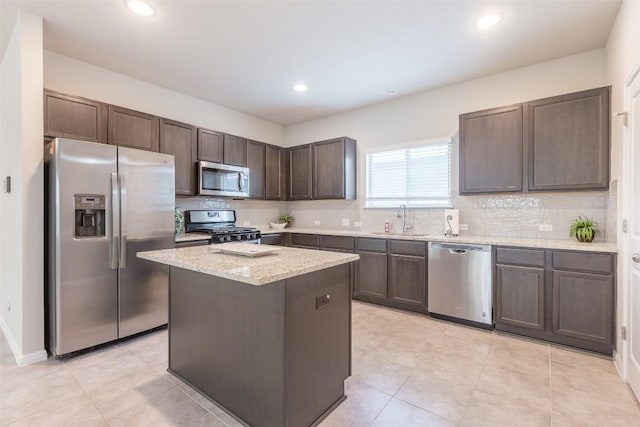 kitchen featuring dark brown cabinetry, stainless steel appliances, tasteful backsplash, and a sink