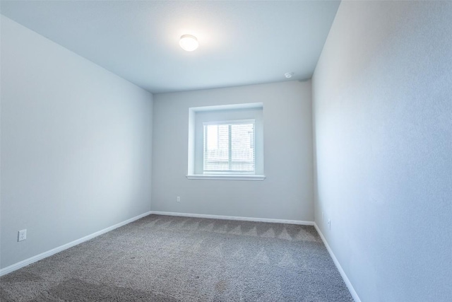 empty room featuring baseboards and carpet floors