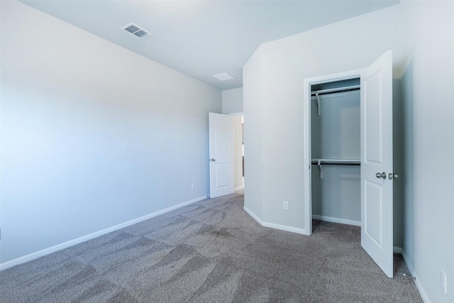 unfurnished bedroom featuring carpet, visible vents, a closet, and baseboards