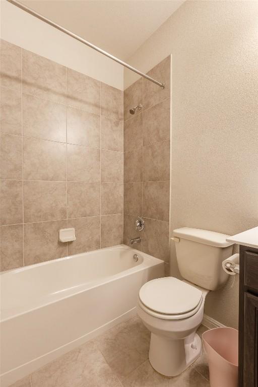 full bath featuring tile patterned flooring, baseboards, toilet, vanity, and  shower combination