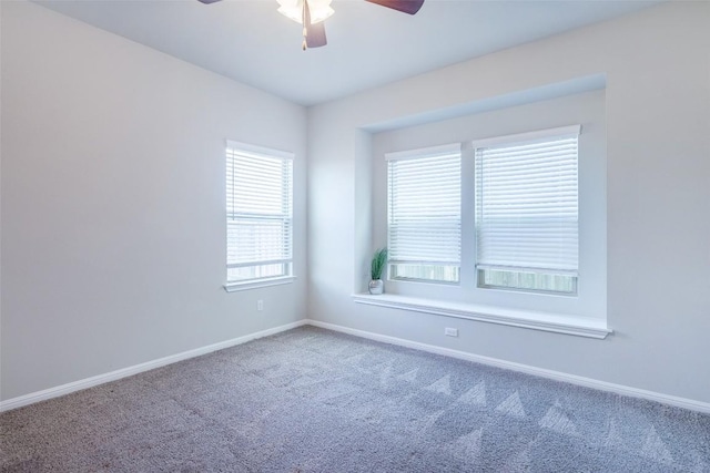 carpeted empty room featuring baseboards and ceiling fan