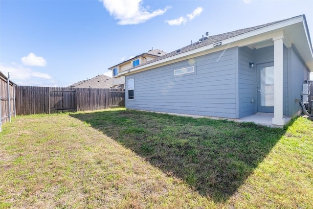 back of property featuring a yard and a fenced backyard