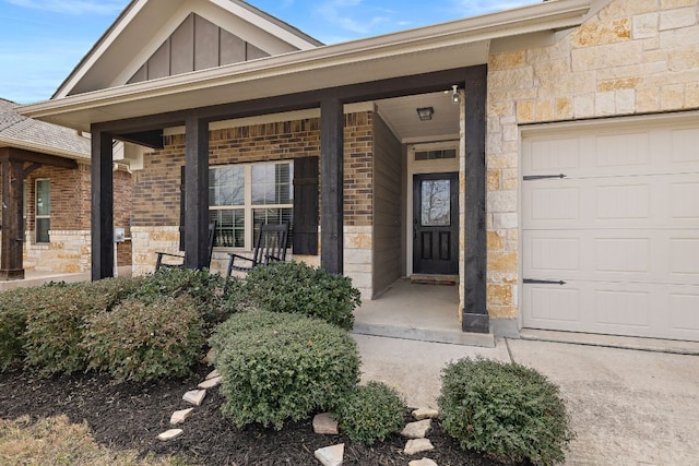 view of exterior entry featuring stone siding, brick siding, board and batten siding, and covered porch