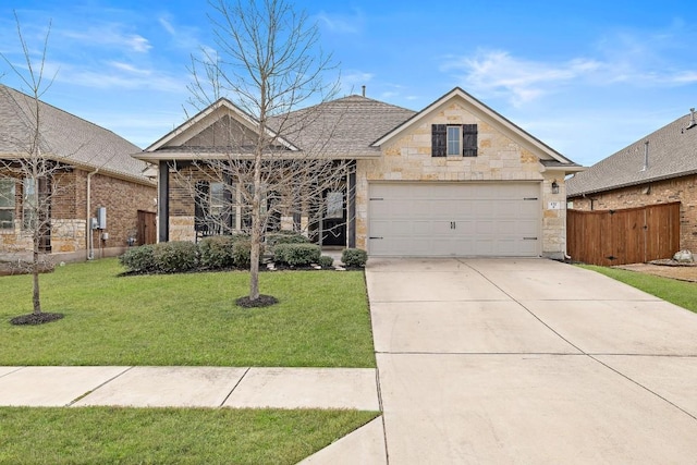 view of front of property featuring fence, driveway, an attached garage, a front lawn, and stone siding