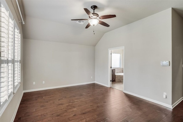 unfurnished room featuring visible vents, baseboards, dark wood-type flooring, and lofted ceiling