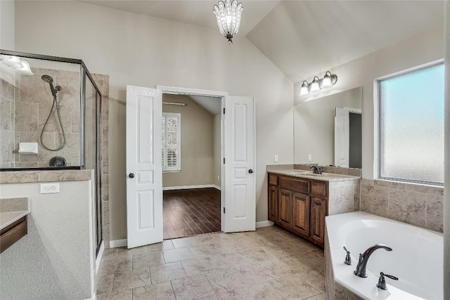 bathroom featuring vanity, a bath, a shower stall, vaulted ceiling, and a notable chandelier