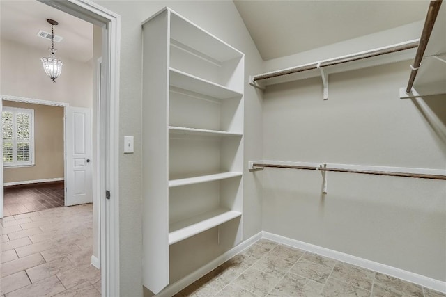 spacious closet with visible vents and a chandelier