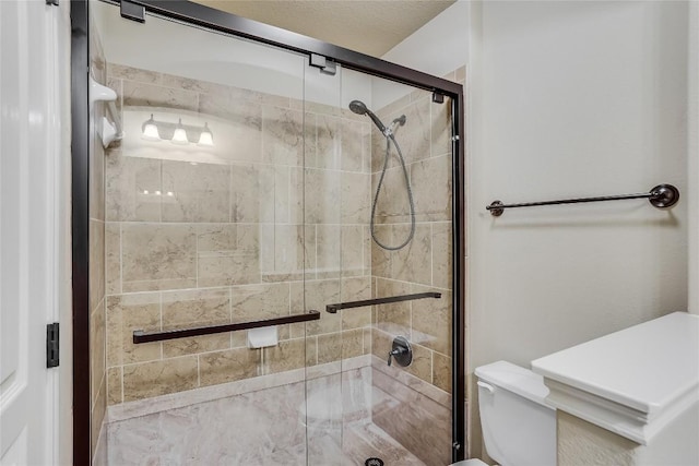 bathroom featuring toilet and a shower stall