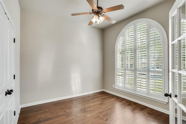 spare room featuring ceiling fan, baseboards, and wood finished floors