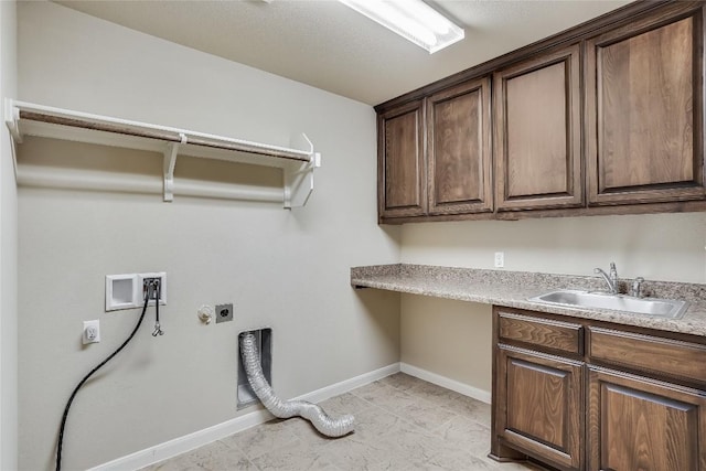 clothes washing area with electric dryer hookup, a sink, cabinet space, baseboards, and hookup for a washing machine