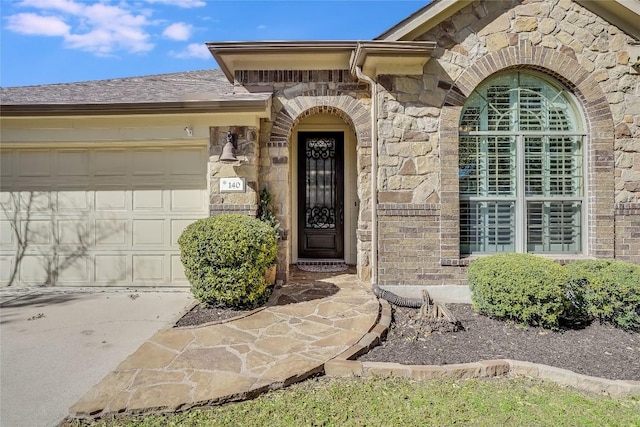 view of exterior entry featuring a garage and stone siding