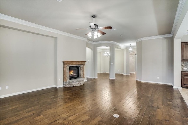 unfurnished living room featuring dark wood-type flooring, a brick fireplace, baseboards, and ceiling fan