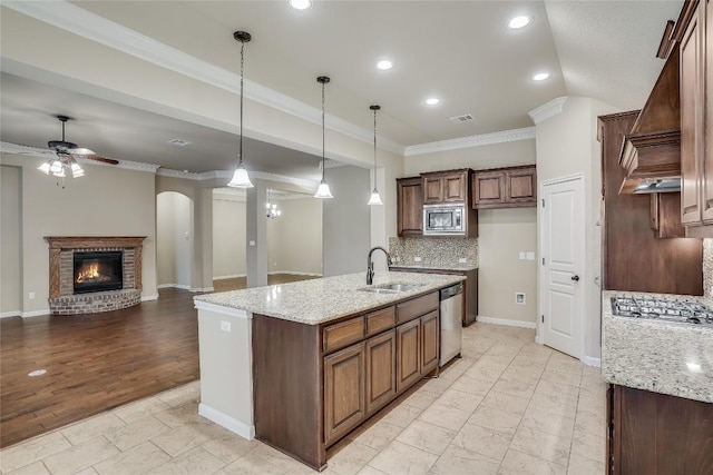 kitchen featuring a ceiling fan, visible vents, a sink, ornamental molding, and stainless steel appliances