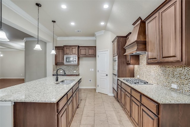 kitchen featuring visible vents, ornamental molding, custom exhaust hood, stainless steel appliances, and a sink