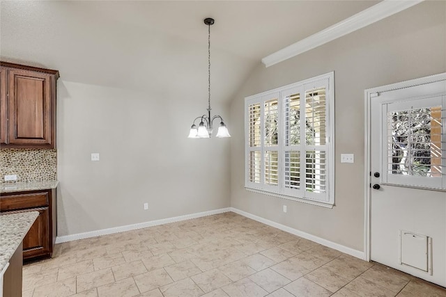 unfurnished dining area with a notable chandelier, crown molding, baseboards, and vaulted ceiling