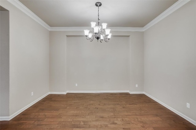 empty room featuring ornamental molding, wood finished floors, baseboards, and a chandelier