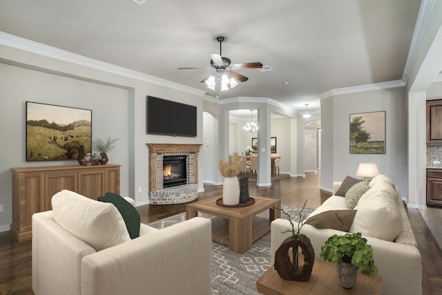 living room featuring ceiling fan, dark wood-style floors, a fireplace, and ornamental molding