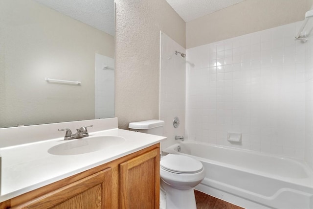 bathroom featuring vanity, bathing tub / shower combination, toilet, and a textured ceiling