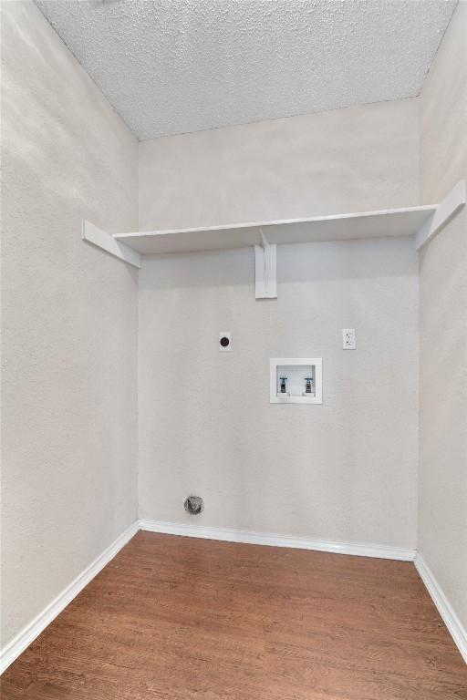 washroom featuring electric dryer hookup, wood finished floors, baseboards, hookup for a washing machine, and laundry area