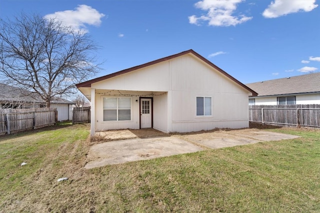 rear view of house with a patio, a lawn, and a fenced backyard