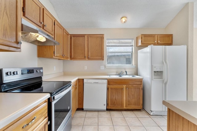 kitchen featuring under cabinet range hood, white appliances, light countertops, and a sink