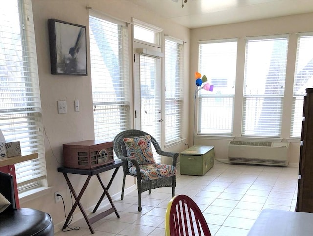 living area with light tile patterned floors, baseboards, and a wealth of natural light