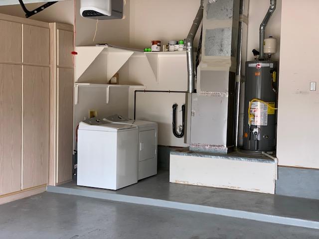 laundry area with water heater and washer and clothes dryer