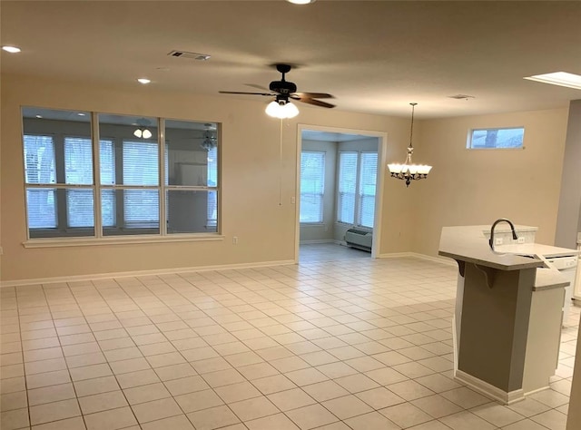 interior space featuring light tile patterned floors, visible vents, plenty of natural light, and ceiling fan with notable chandelier