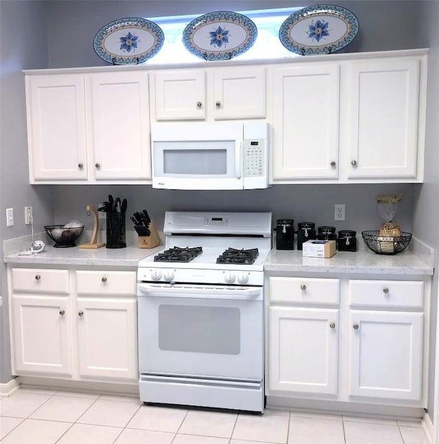 292 Whispering Wind Dr, Georgetown, TX 78633 - kitchen featuring white appliances, white cabinetry, light countertops, and light tile patterned flooring
