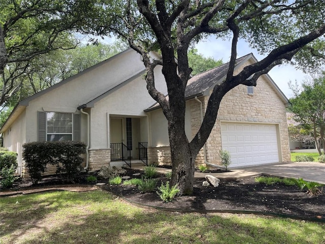 292 Whispering Wind Dr, Georgetown, TX 78633 - view of front of house featuring stone siding, a garage, driveway, and stucco siding