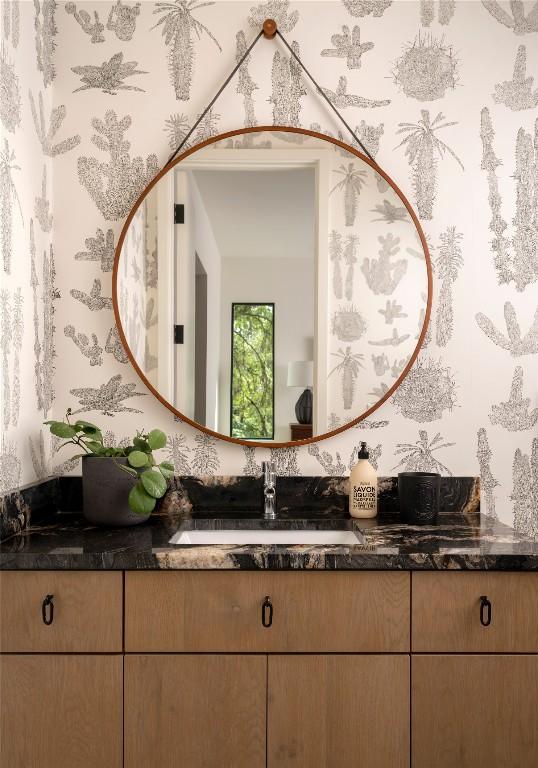 bathroom with vanity and wallpapered walls