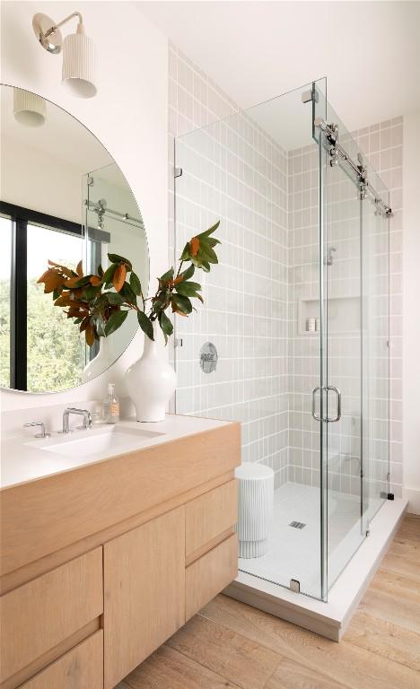 bathroom featuring a stall shower, vanity, and wood finished floors