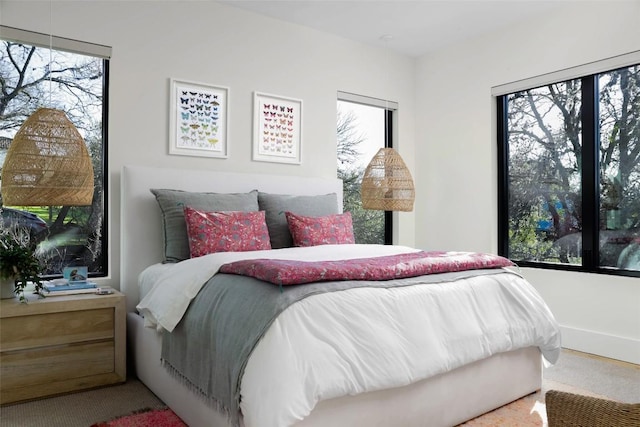 carpeted bedroom featuring multiple windows