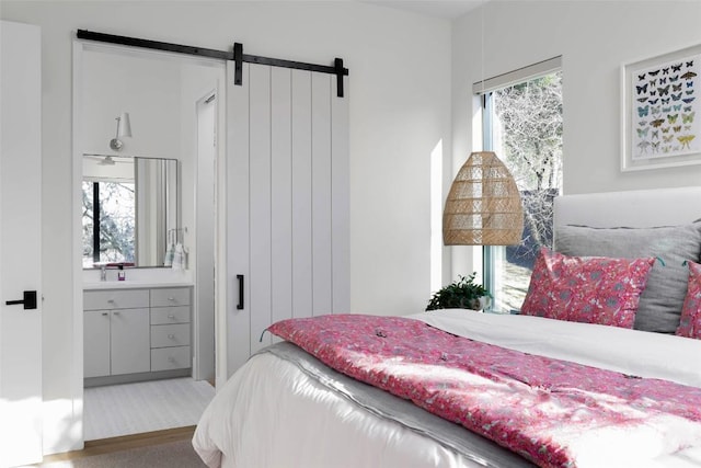 bedroom featuring a barn door, multiple windows, and carpet