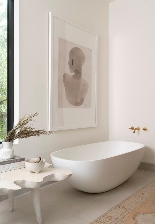 bathroom featuring tile patterned flooring and a freestanding tub