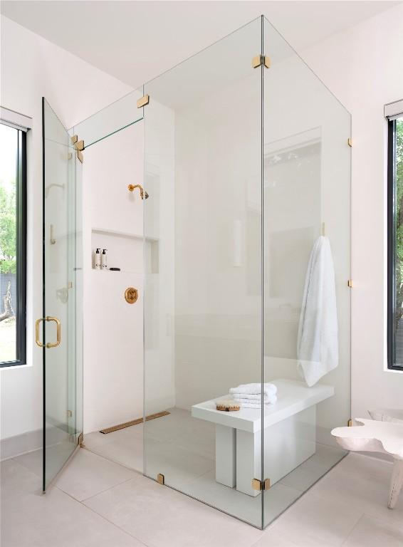 bathroom with a wealth of natural light, tile patterned floors, and a stall shower