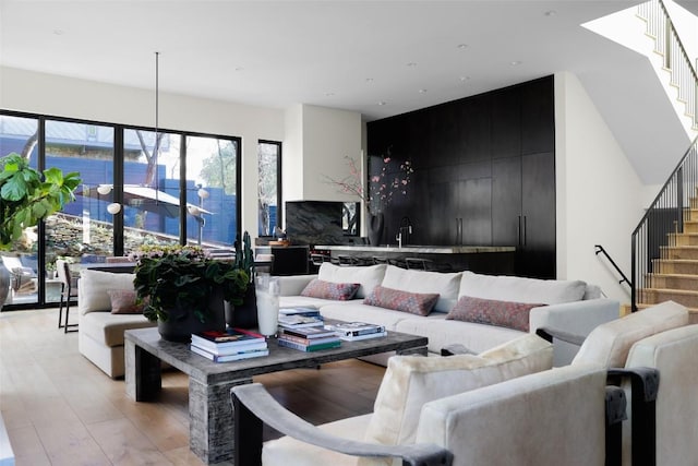 living area featuring light wood finished floors and stairs