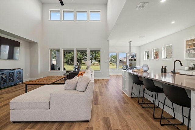 living area featuring visible vents, ceiling fan, baseboards, recessed lighting, and light wood-style floors