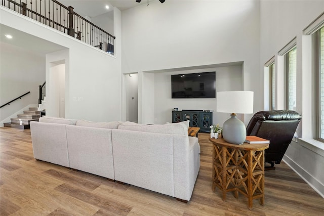 living area featuring stairway, wood finished floors, baseboards, and a wealth of natural light