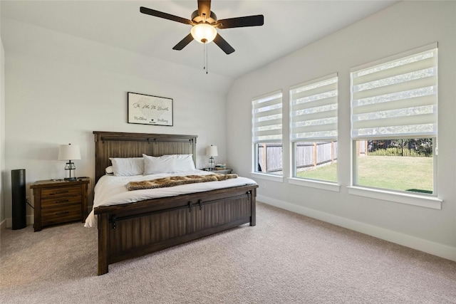 bedroom featuring light carpet, a ceiling fan, baseboards, and vaulted ceiling