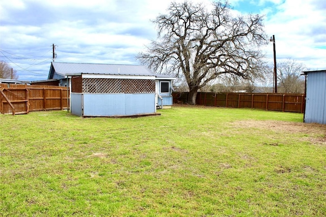 view of yard with an outdoor structure and a fenced backyard