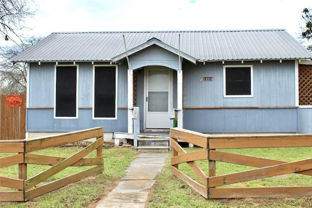 view of front of house with metal roof and fence