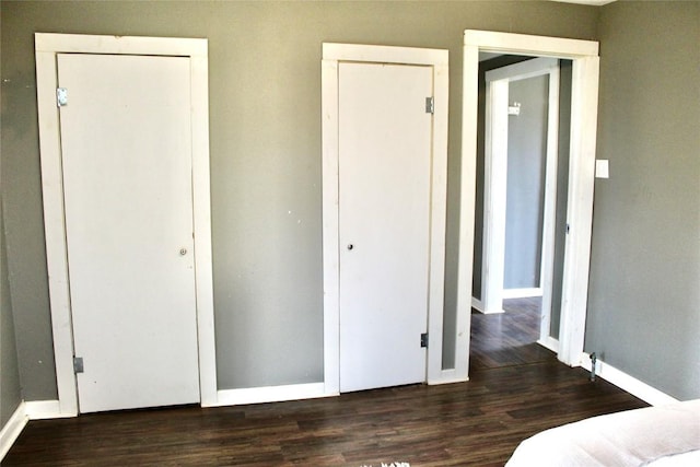 1221 Giddings St, Lexington, TX 78947 - unfurnished bedroom with wood finished floors, baseboards, and multiple closets