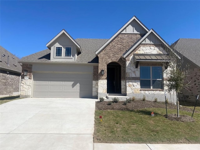 view of front of house featuring stone siding, concrete driveway, a front lawn, and roof with shingles