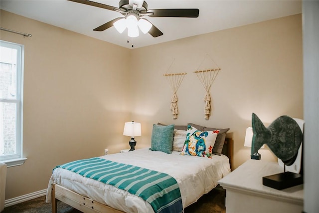 bedroom with a ceiling fan and baseboards