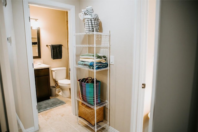 half bathroom featuring vanity, toilet, and tile patterned flooring