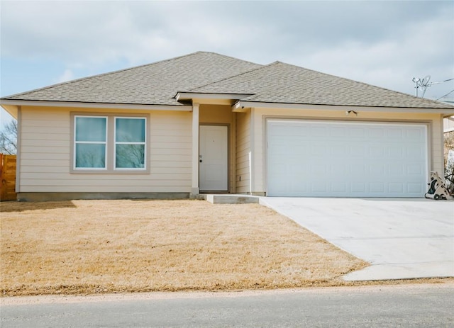 view of front of home featuring driveway, roof with shingles, and an attached garage