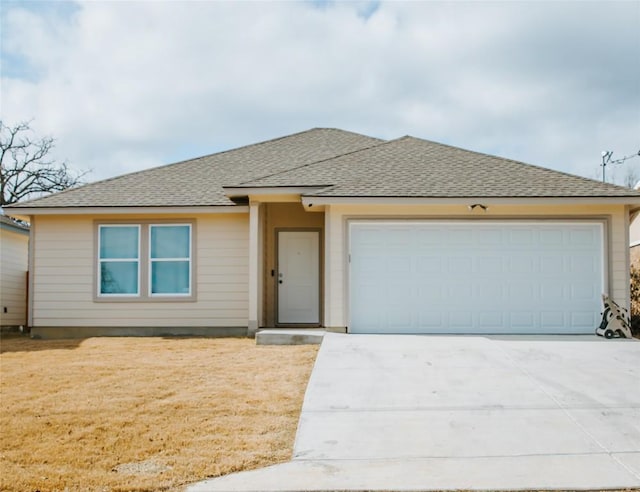 view of front facade with an attached garage, a front lawn, driveway, and roof with shingles