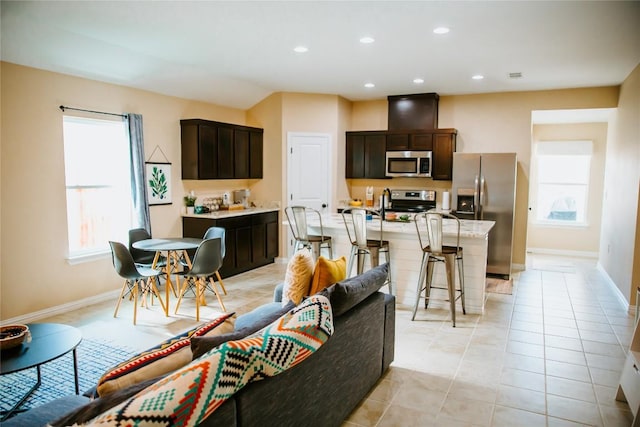 living room with a wealth of natural light, recessed lighting, and baseboards